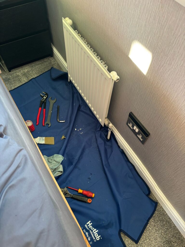 Radiator work with tools and a protective floor mat