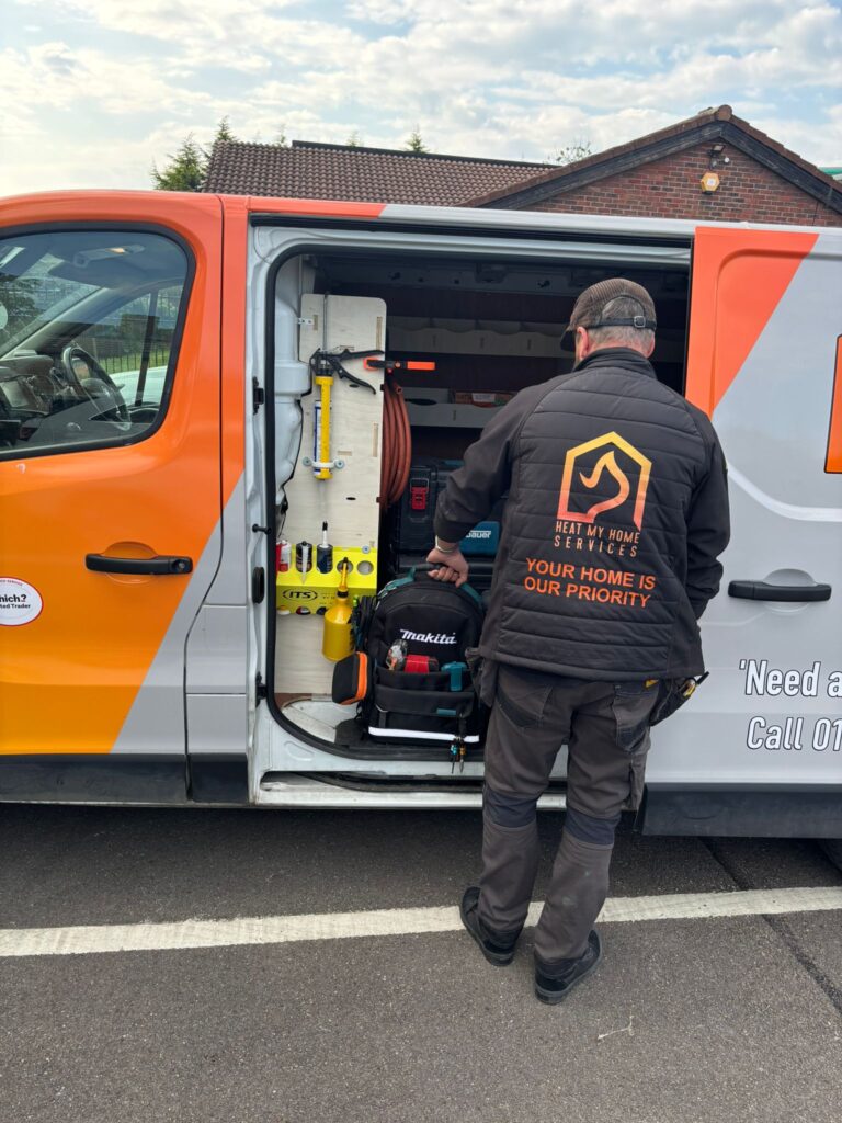 Heat My Home Services engineer collecting tools from a branded van