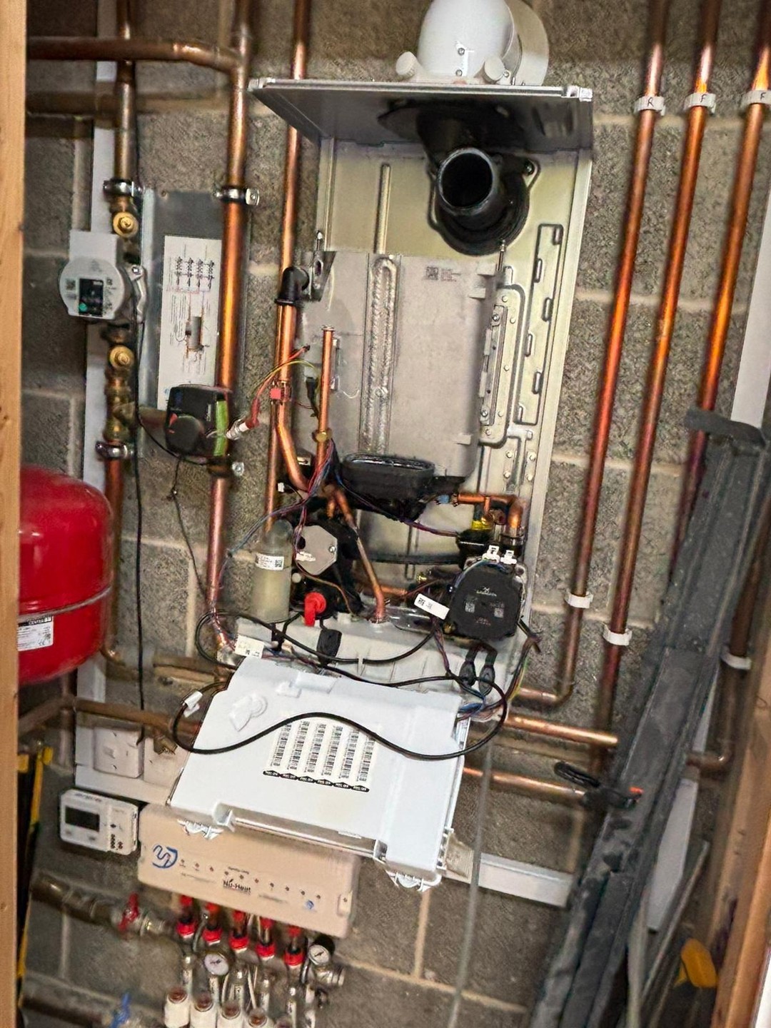 Boiler opened for servicing with heating-system pipework visible