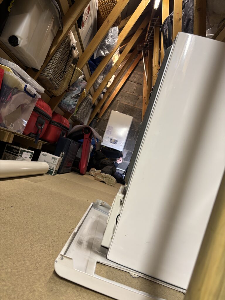 Engineer working in the loft boiler installation area in Tingley